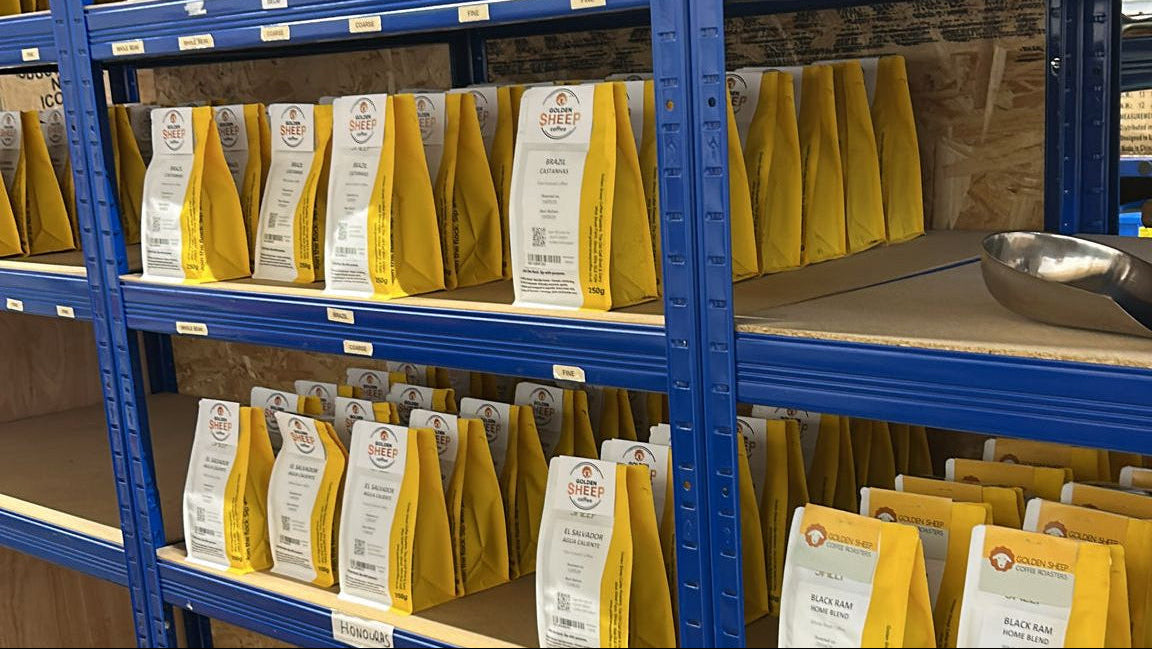Golden Sheep Coffee warehouse shelving stocked with yellow bags of  golden sheep coffee in Stroud