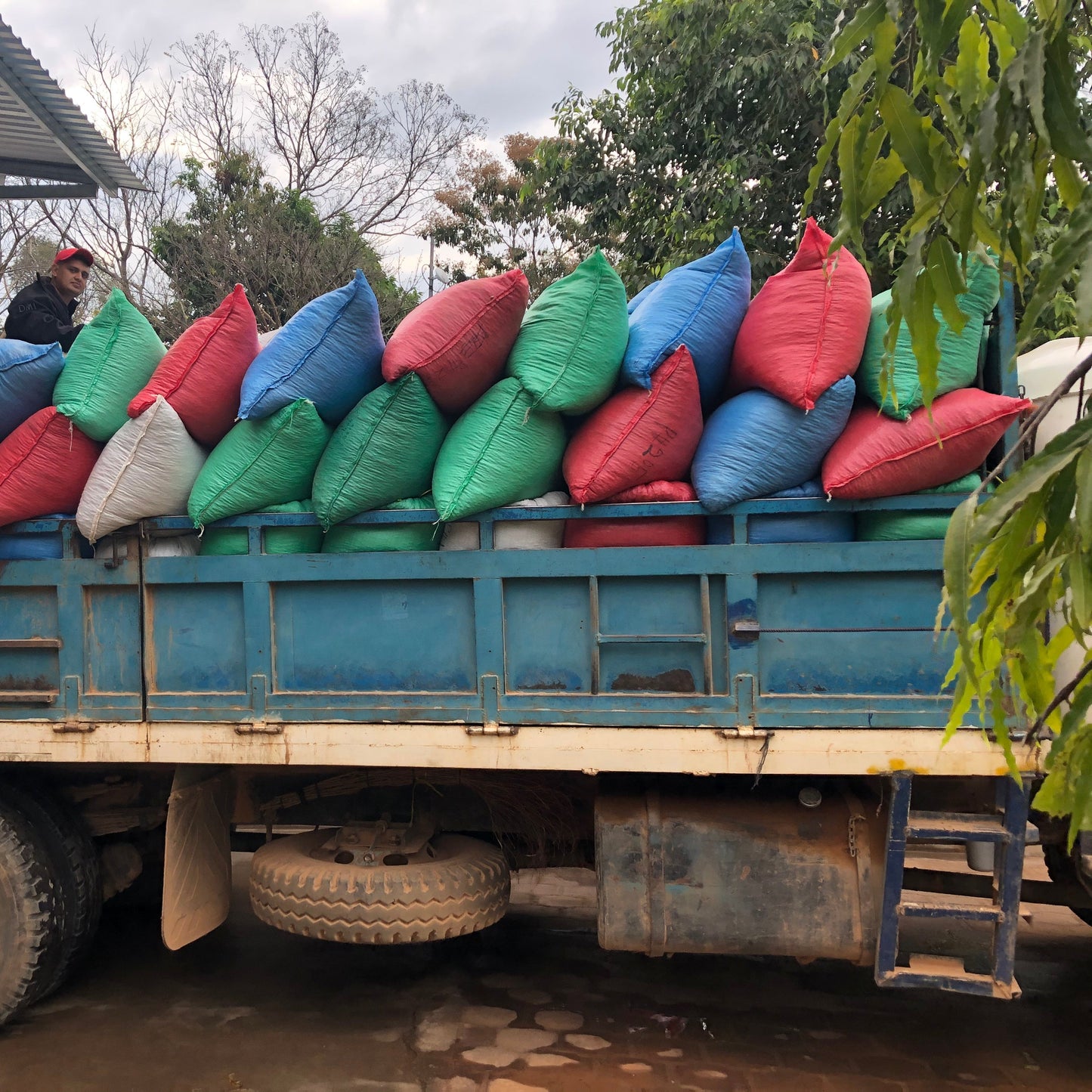 Truck carrying colorful bags on a rural road