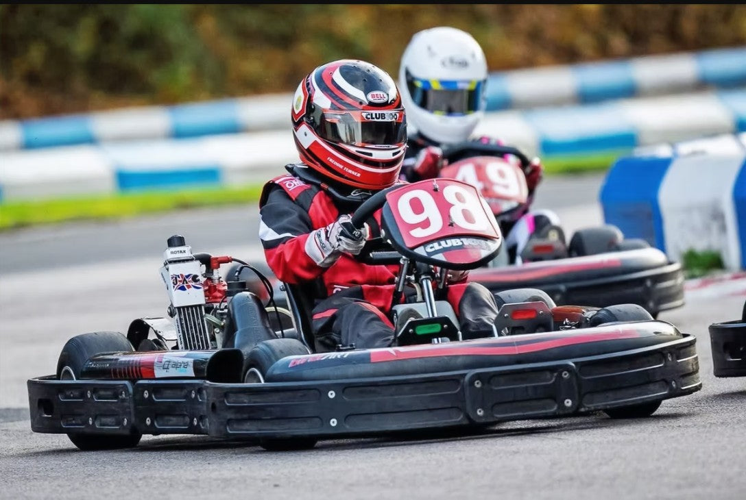 Two go-kart racers on a track with one prominently displaying the number 98.